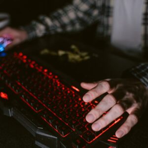 Close-up of hands using backlit mechanical keyboard, ideal for gaming and technology themes.